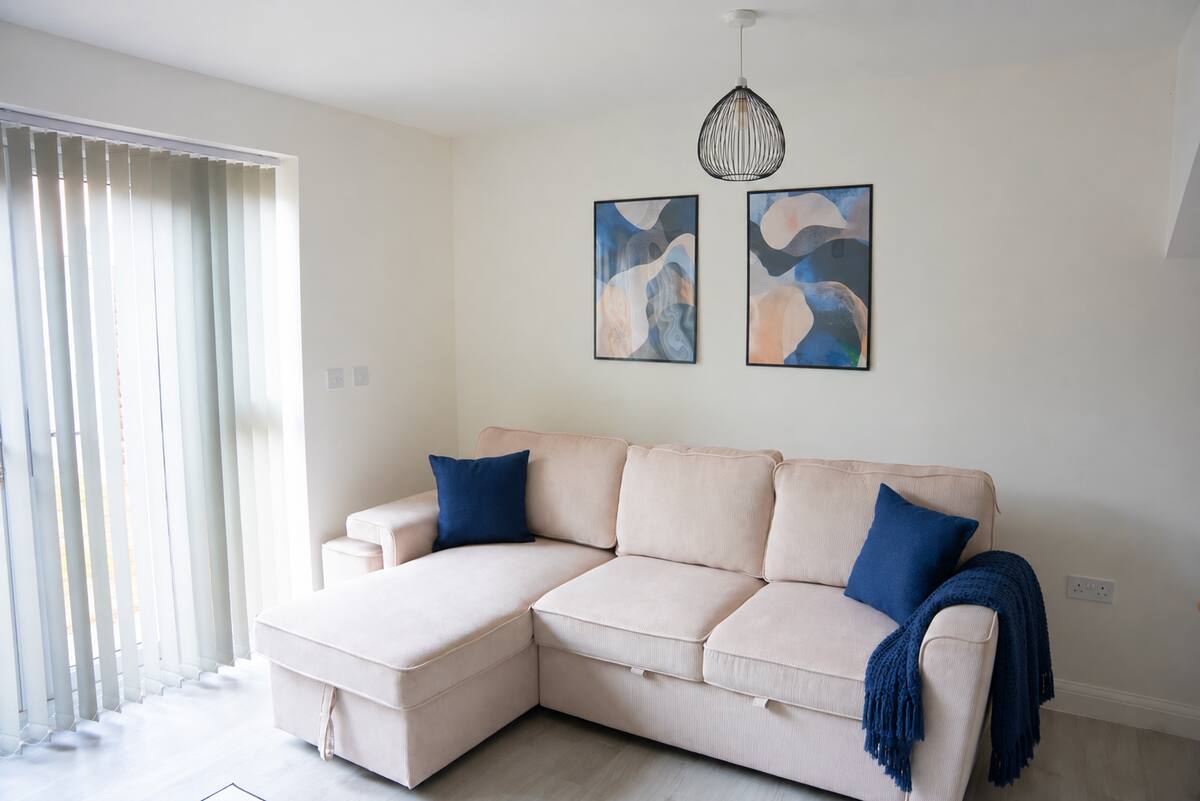 Propora Stays Birmingham — living area with corner sofa and artwork